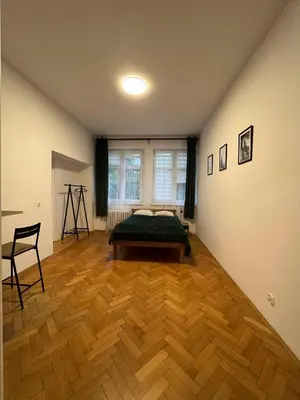 a bedroom with a bed and a wooden floor at Krowoderska Lovely Room in Kraków