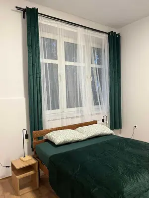 a bedroom with a green bed and a window at Krowoderska Lovely Room in Kraków
