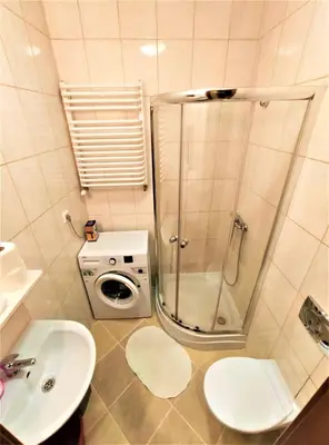 a bathroom with a shower and a washing machine at Abak Krakow Apartment in Kraków
