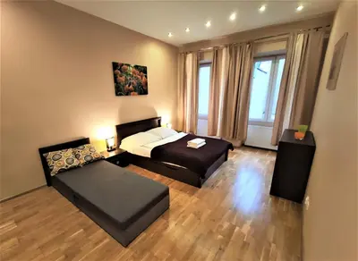 a bedroom with two beds and a large window at Abak Krakow Apartment in Kraków