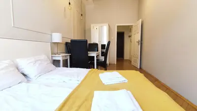 a bedroom with a bed and a table with chairs at Floriańska 10 C-D by Homeprime in Kraków