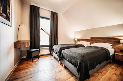 two beds in a hotel room with a window at Jurajski Zakątek in Skała