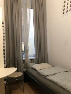 a bedroom with a window with a bed and a table at Mini in Kraków