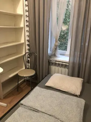 a bedroom with a bed and a chair and a window at Mini in Kraków