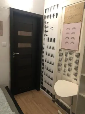 a door in a room with a wall of wine bottles at Mini in Kraków