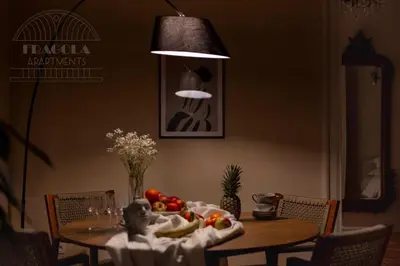 a table with fruits and vegetables on it with a lamp at Fragola Apartments Le Jardin - classy, spacious Old Town apartments in Kraków