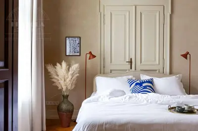a bedroom with a white bed with blue and white pillows at Fragola Apartments Le Jardin - classy, spacious Old Town apartments in Kraków