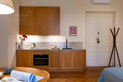 a small kitchen with wooden cabinets and a table at Fragola Apartments Le Jardin - classy, spacious Old Town apartments in Kraków