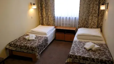 a hotel room with two beds and a window at Ośrodek SCSK Optima in Kraków