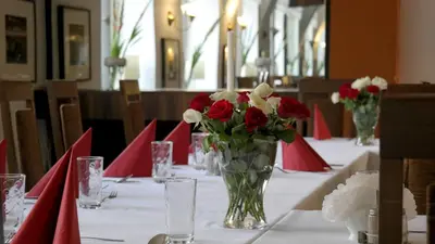 a table with red and white flowers in a vase at Ośrodek SCSK Optima in Kraków
