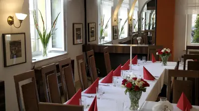 a dining room with tables and chairs with flowers on them at Ośrodek SCSK Optima in Kraków
