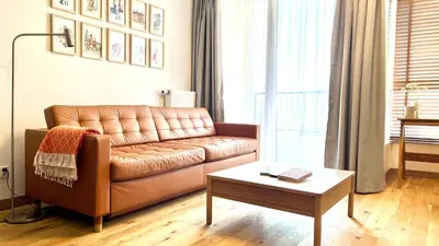 a living room with a brown leather couch and a table at MintKrak in Kraków