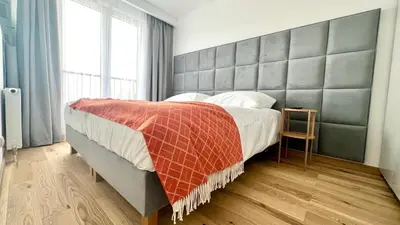 a bedroom with a large bed with a large headboard at MintKrak in Kraków