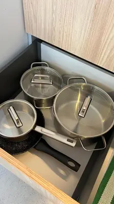 four metal pans sitting on a shelf in a kitchen at MintKrak in Kraków