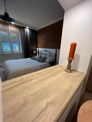 a bedroom with two beds and a table with a candle on it at Apartamenty K9 in Kalwaria Zebrzydowska
