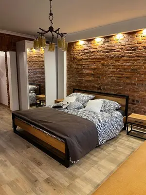 a bedroom with a bed and a brick wall at Apartamenty K9 in Kalwaria Zebrzydowska