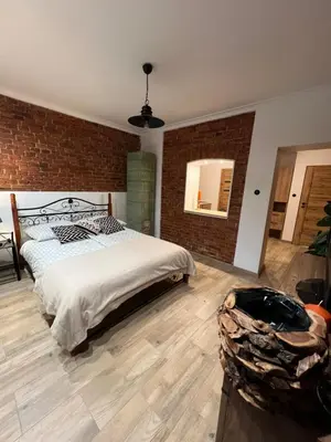a bedroom with a bed and a brick wall at Apartamenty K9 in Kalwaria Zebrzydowska