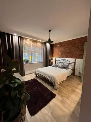 a bedroom with a bed and a brick wall at Apartamenty K9 in Kalwaria Zebrzydowska