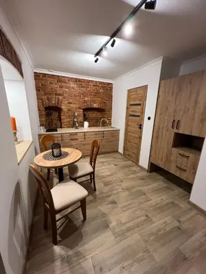 a kitchen with a table and chairs in a room at Apartamenty K9 in Kalwaria Zebrzydowska