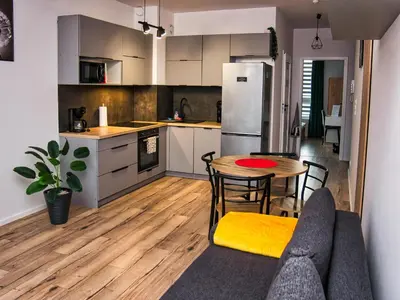 a kitchen and dining room with a table and a couch at Apartament Bazylek, miejsce parkingowe w garażu podziemnym in Kraków