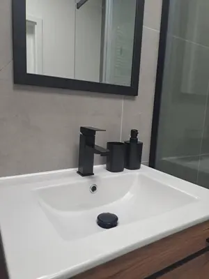 a bathroom sink with a black faucet and a mirror at Apartament Bazylek, miejsce parkingowe w garażu podziemnym in Kraków