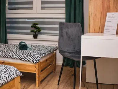 a bedroom with a bed and a chair next to a desk at Apartament Bazylek, miejsce parkingowe w garażu podziemnym in Kraków