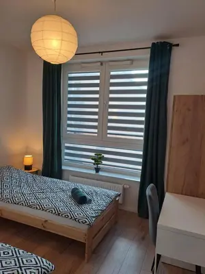 a bedroom with a bed and a large window at Apartament Bazylek, miejsce parkingowe w garażu podziemnym in Kraków