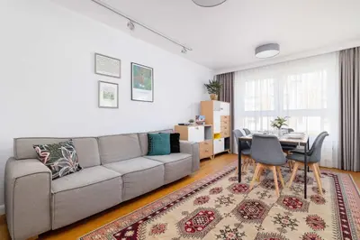 a living room with a couch and a table at Przytulny i Przestronny Apartament w Krakowie z Parkingiem Biurkiem i 2 Balkonami by Noclegi Renters in Kraków
