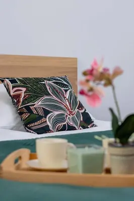 a bed with a tray with a cup and a pillow at Przytulny i Przestronny Apartament w Krakowie z Parkingiem Biurkiem i 2 Balkonami by Noclegi Renters in Kraków