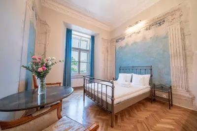 a bedroom with a bed and a table with a vase of flowers at Apartamenty pod Jagnięciem - Rynek Główny in Kraków