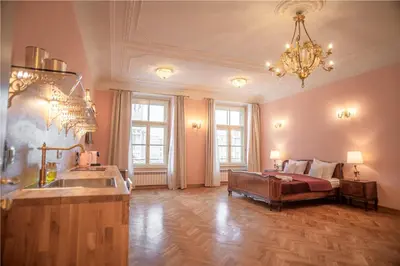 a large living room with a bed and a chandelier at Apartamenty pod Jagnięciem - Rynek Główny in Kraków