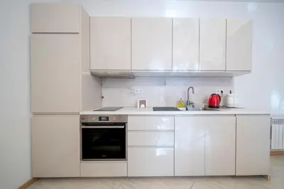 a white kitchen with white cabinets and a sink at Apartamenty pod Jagnięciem - Rynek Główny in Kraków