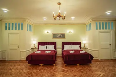 a bedroom with two beds and a chandelier at Apartamenty pod Jagnięciem - Rynek Główny in Kraków