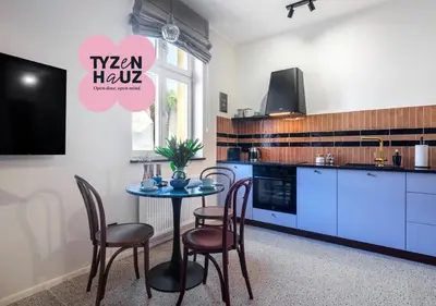 a kitchen with a table with chairs and a tv at Kalwaryjska by Tyzenhauz in Kraków