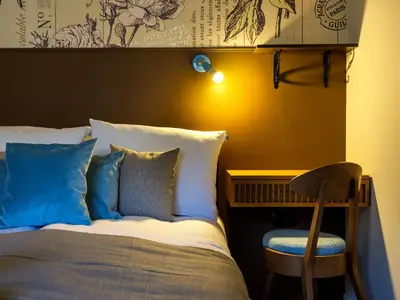 a bed with blue pillows and a chair in a room at Kalwaryjska by Tyzenhauz in Kraków