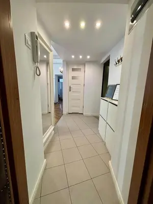 a hallway leading to a kitchen with white appliances at Vintage Senacka 3 Apartment in Kraków