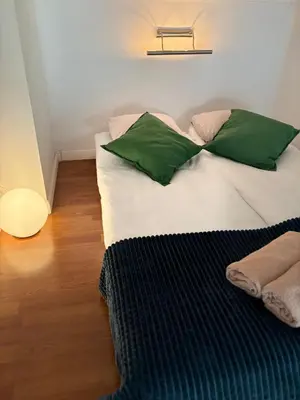 a large bed with green pillows in a room at Vintage Senacka 3 Apartment in Kraków