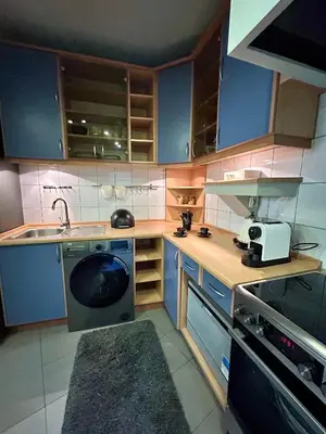 a small kitchen with blue cabinets and a sink at Vintage Senacka 3 Apartment in Kraków