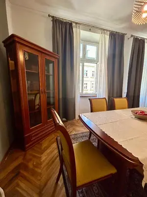 a dining room with a table and chairs and a cabinet at Vintage Senacka 3 Apartment in Kraków