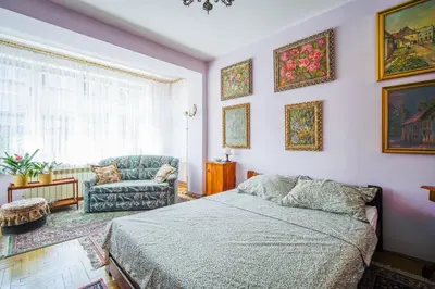 a bedroom with a bed and a chair and a window at Painter's house in Kraków