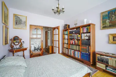 a bedroom with a bed and a book shelf at Painter's house in Kraków