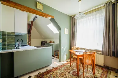 a kitchen and dining room with a table and chairs at Painter's house in Kraków