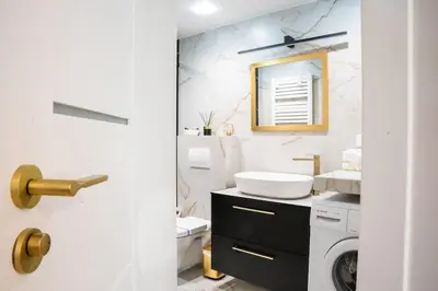 a bathroom with a sink and a washing machine at Apartment w ogrodzie w sercu starego Krakowa in Kraków