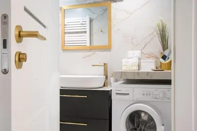 a bathroom with a washing machine and a sink at Apartment w ogrodzie w sercu starego Krakowa in Kraków