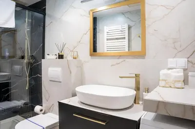 a white bathroom with a sink and a mirror at Apartment w ogrodzie w sercu starego Krakowa in Kraków