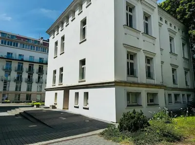 a large white building with a lot of windows at Apartment w ogrodzie w sercu starego Krakowa in Kraków