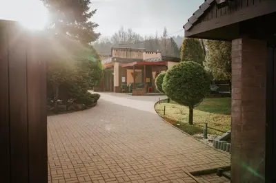 a brick walkway in front of a building with the sun shining at Apartamenty pod Dzwonkiem in Wadowice