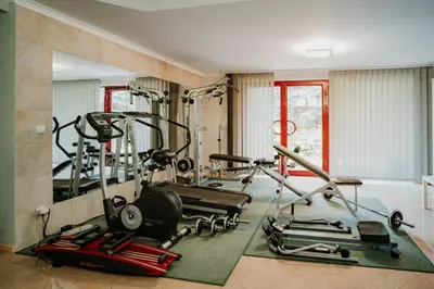 a gym with several tread machines and a mirror at Apartamenty pod Dzwonkiem in Wadowice