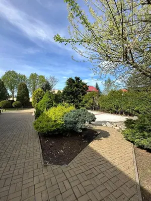 a garden with bushes and a brick walkway at Apartamenty pod Dzwonkiem in Wadowice