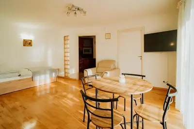 a living room with a table and chairs and a bed at Apartamenty pod Dzwonkiem in Wadowice
